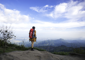 Fototapeta premium Hiker woman look binoculars on the mountain, background blue sky, Thailand