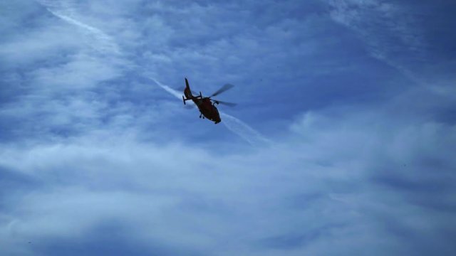 Helicopter flying against blue sky. Air transport aviation. Helicopter rescue. Helicopter silhouette at blue sky. Aircraft transportation. Emergency airplane flying in sky. Flight transport