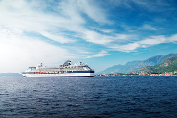 Cruise liner ship swimming at blue adriatic sea, mountains landscape