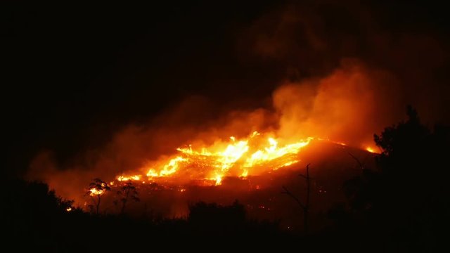 A bushfire burning orange and red at night
