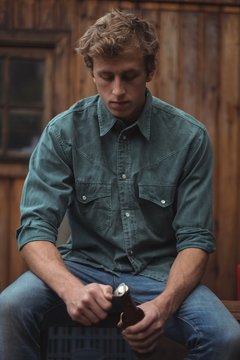 Young Man Opening Beer Bottle