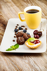 Cup of coffee and pastry on wooden background