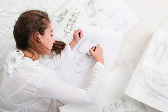 Woman Drawing Pencil Portrait On Floor In Workshop. Attractive Female Artist Sketching Human Portrait. Art, Inspiration, Creativity, Talent, Craft Concept