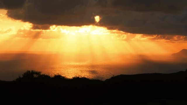 sunlight throw the clouds in yellow sunset on the sea: Sicily, Italy, summer