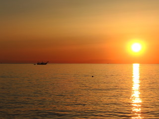 Fishing boats pull their nets at the sunrise. Adriatic cost. Emilia Romagna. Italy.
