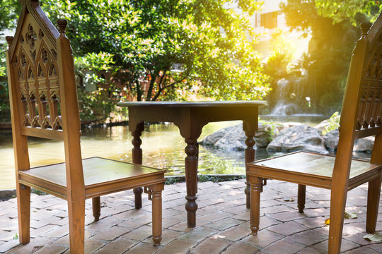 wood chair and table at waterside of pond
