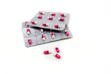 Pink and white pills in blister packs isolated on white background