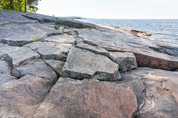 Ancient petroglyphs (rock engravings of 4th-2nd millennia BC) that depict demon figure, muskrat and swan carved on granite Onega Lake shore. Besov Nos cape, Karelia Republic, Russia.

