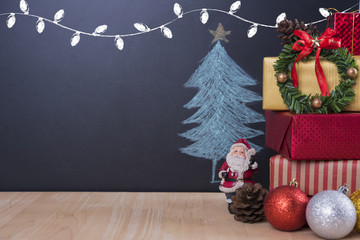 Christmas table with decorations and gift box on christmas tree background.