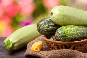 green zucchini and courgettes on sackcloth with a blurred background