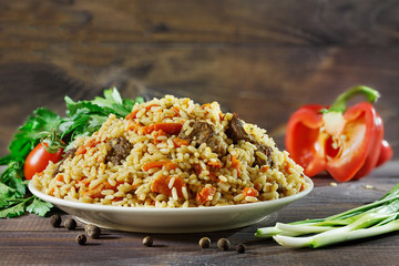 Pilaf, on background Woody. Fried Lamb, rice, Garlic, Carrot.