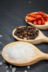 Chili with black pepper and salt on rustic stone background. Overhead view food photography