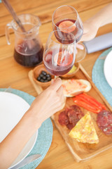 Two friends toasting with sangria over the tapa plate