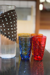 water jug and colorful glass, on table in cafe restaurant
