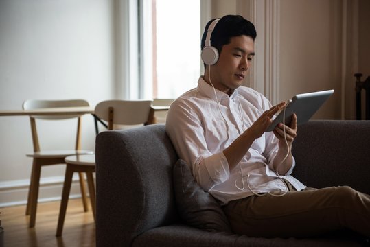 Man listening music on digital tablet
