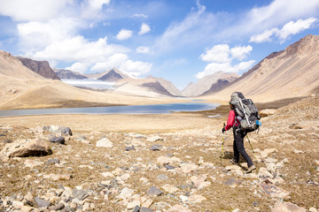 backpacker on background mountain lake, central Asia, Kyrgyzstan