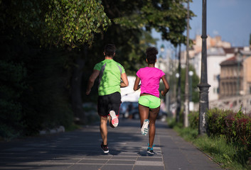 young smiling multiethnic couple jogging in the city