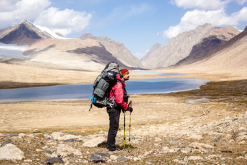 backpacker on background mountain lake, central Asia, Kyrgyzstan