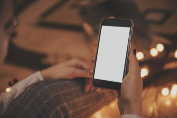 Girl using mobile phone in a home atmosphere - hipster look with blank space.