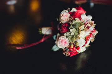 beautiful red wedding bouquet with ribbons on the table