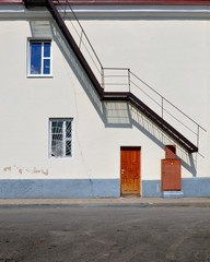 Front view of the facade with a fire staircase casts a shadow. Geometric composition.