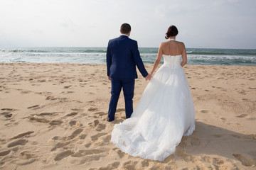 Fototapeta na wymiar walking couple on sand beach with love during wedding day