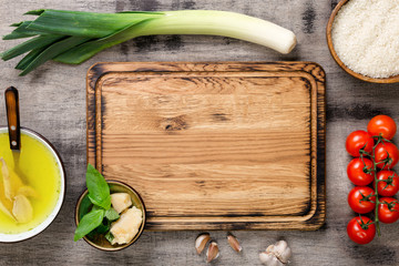 Ingredients for cooking risotto around cutting board on wooden t
