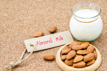 Almond and almond milk in glass with almond tag.