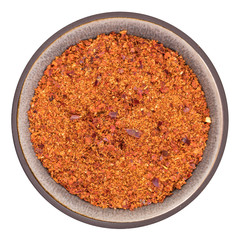 Organic Harissa herb in ceramic bowl isolated on white background, top view
