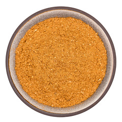 Organic vindaloo curry powder in ceramic bowl isolated on white background, top view