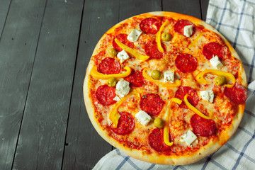 Fresh tasty pizza on wooden background