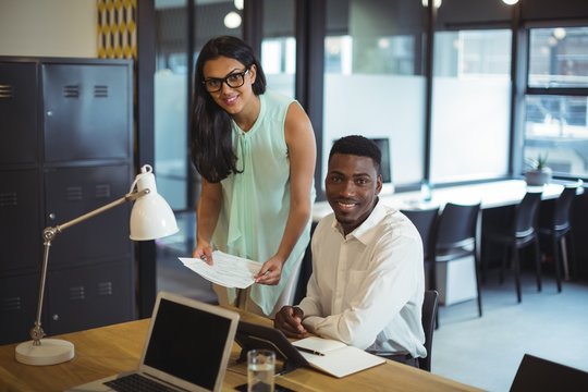 Businessman and a colleague discussing over document