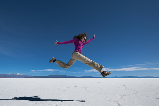 A girl leaps into the air at the Salinas Grandes (salt flats) near Purmamarca, Argentina