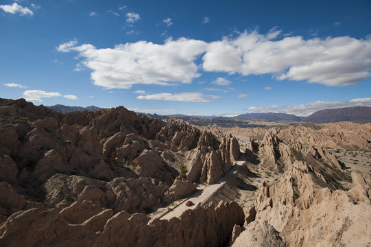 A car passes through the stunning rock formations of the Quebrada de las Flechas, Argentina