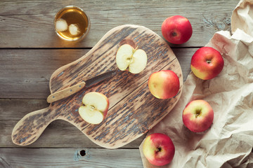 apples on a cutting board and glass of juice