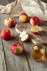 glass of juice and apples on a cutting board