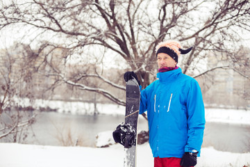 Fototapeta na wymiar Smiling man in a funny hat with snowboard