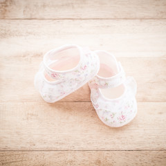 baby girl's shoes on a wooden floor retro vintage style