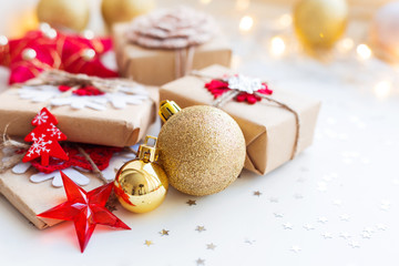 Christmas and New Year background with golden decorative ball, presents and decorations for Christmas tree. Holiday background with stars confetti and light bulbs. Place for text.