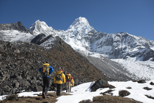 A team of four climbers make their way to Ama Dablam Base Camp, the 6856m peak seen in the distance, Khumbu Region, Himalayas, Nepal