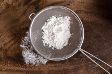 Wheat flour in a sieve on wooden background,food ingredient,prepare for cooking or baking