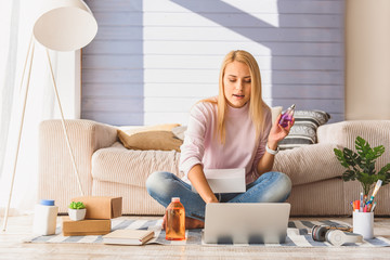 Excited young woman doing online shopping