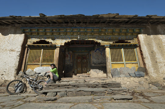A mountain biker takes a well earned rest at Mu Gompa, the last village in the Tsum Valley, Nepal