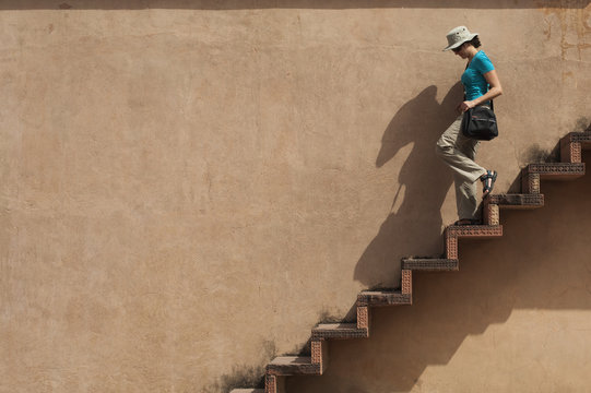 A tourist climbs downs some exposed steps within the Fatehpur Sikri temple complex, Uttar Pradesh