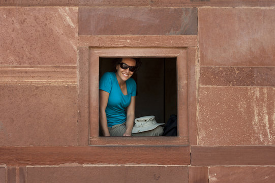 A tourist peeks out from one the windows within the Fatehpur Sikri temple complex, Uttar Pradesh