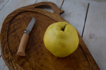 apple quince and knife  on a wooden background. Rustic style