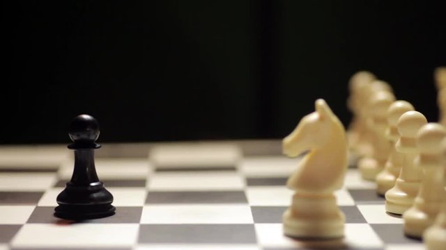 Dolly footage of a chess match, with white knight capturing the black pawn.