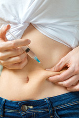 Woman giving herself insulin shot injection.
