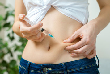 Woman giving herself insulin shot injection. - obrazy, fototapety, plakaty