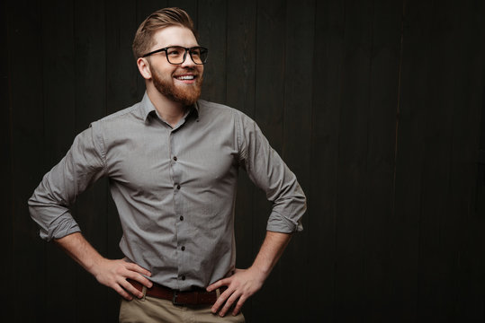 Man in eyeglasses standing with hands on hips